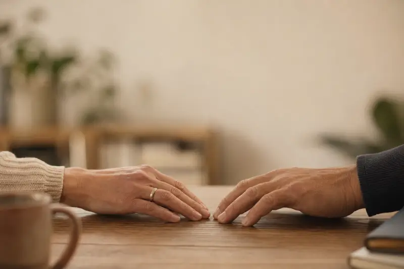 שתי ידיים על שולחן עץ, רגע אחרי שנפרדו זו מזו — גישור גירושין